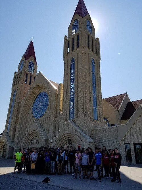 Grade 9 retreat picture with students in front of a church